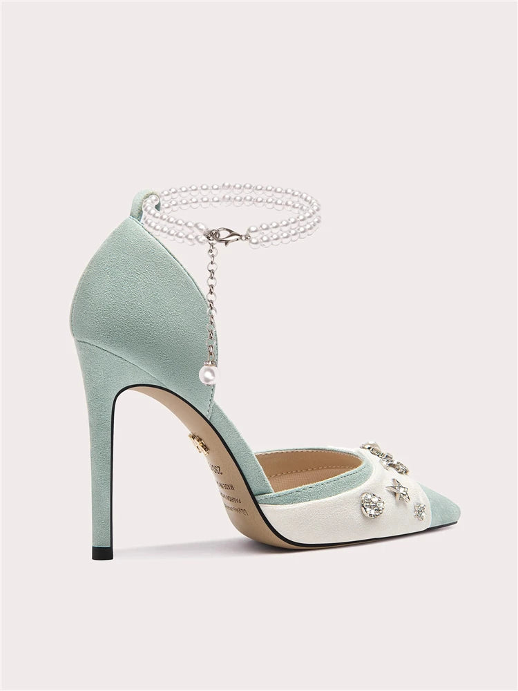 Teal high-heeled shoe with pearl embellishments on a light gray background