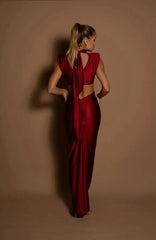 Woman wearing a red dress with cut-out design against a beige background