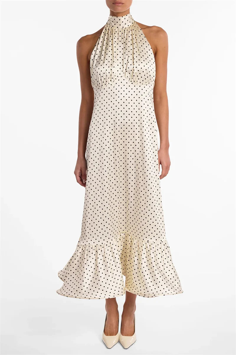 White halter neck dress with black polka dots on a white background