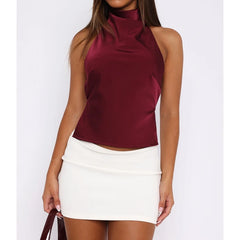 Woman wearing a burgundy top and white skirt on a white background