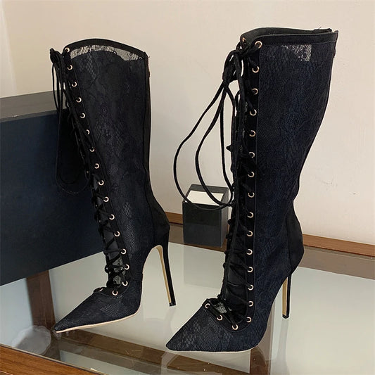 Pair of lace-up knee-high boots on a glass surface