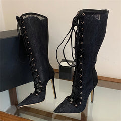Pair of lace-up knee-high boots on a glass surface