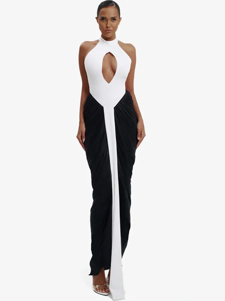 Woman wearing a black and white dress with a high slit on a white background