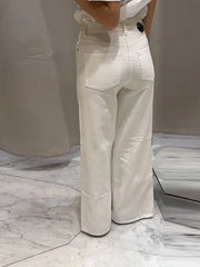 Person wearing light-colored pants standing on a marble floor.