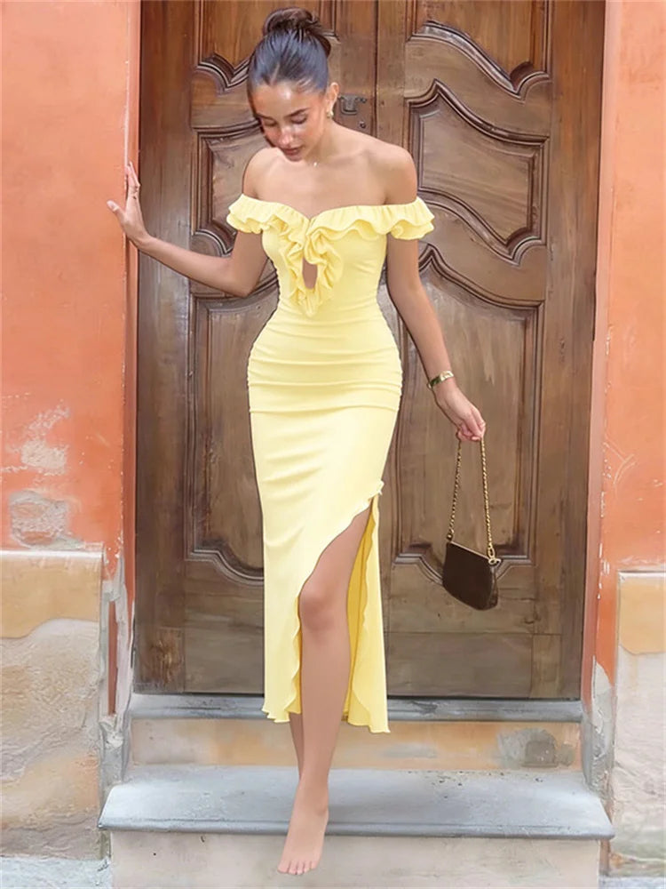 Woman in a yellow off-shoulder dress standing in front of a wooden door.