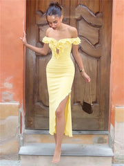 Woman in a yellow off-shoulder dress standing in front of a wooden door.