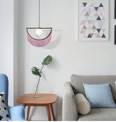 A modern Nordic tassel chandelier with glass ball pendants hanging in a minimalist Drawing -room J