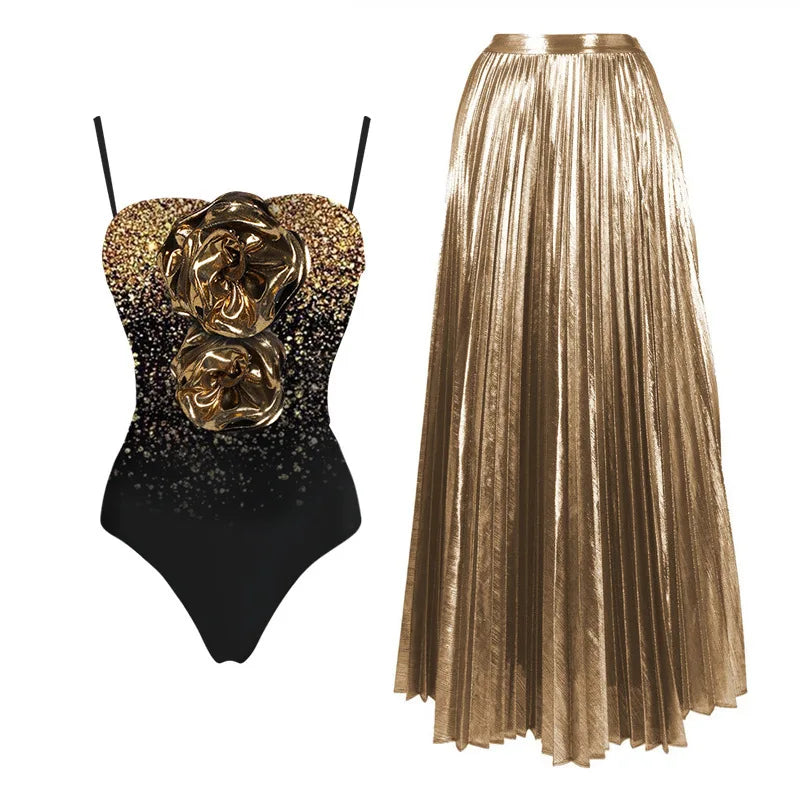 Black one-piece swimsuit with gold glitter and 3D floral embellishments, paired with a gold pleated maxi skirt