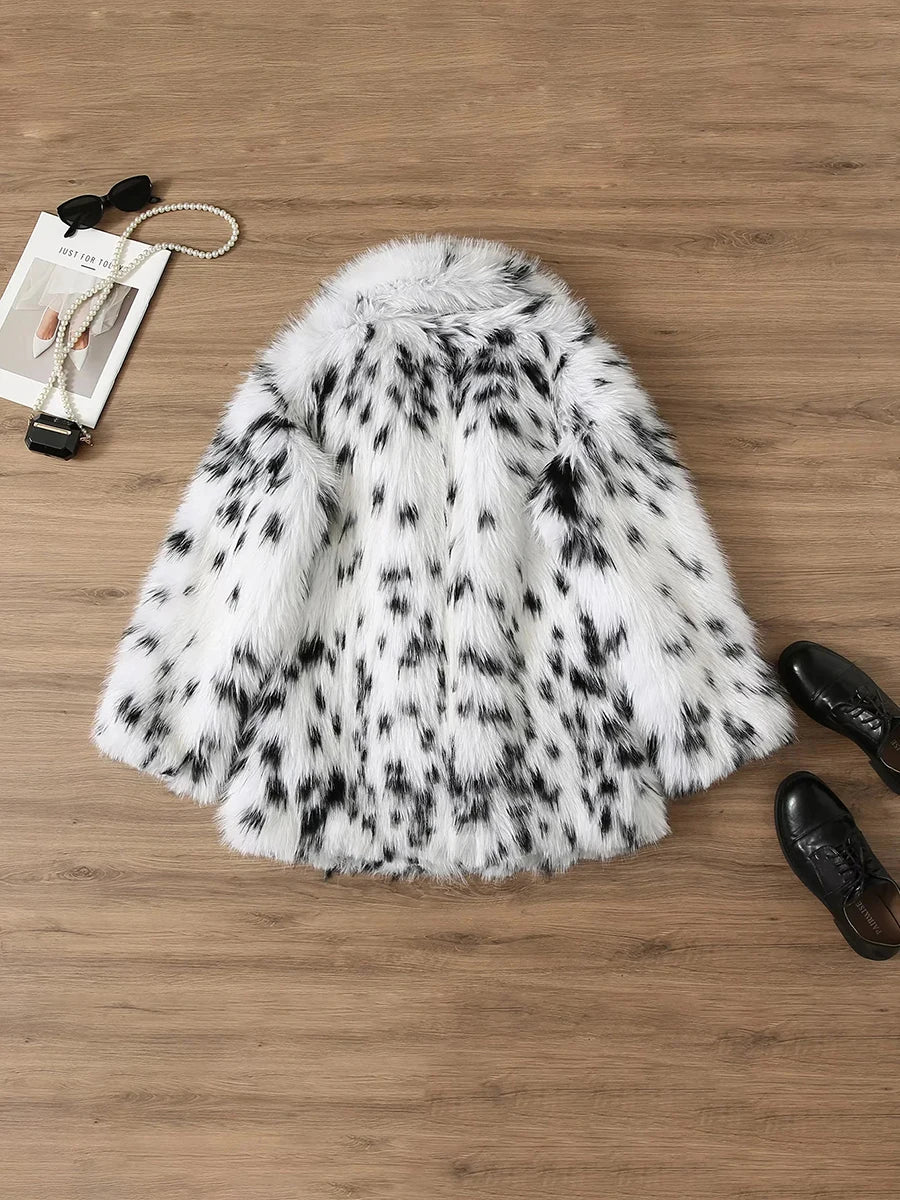 White fur coat with black spots on a wooden surface