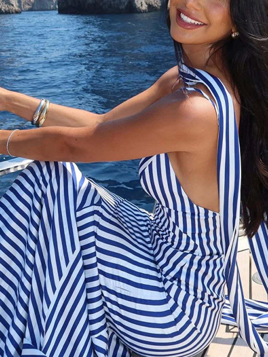 Woman in a blue and white striped dress by the water