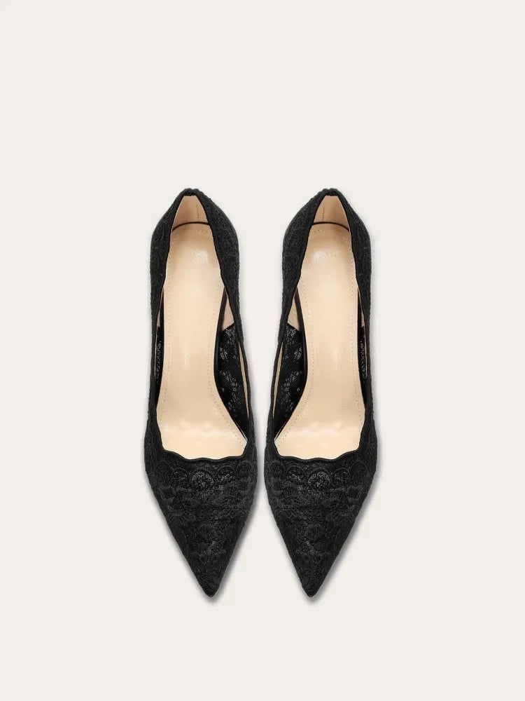 Pair of black pointed-toe high heels on a light gray background