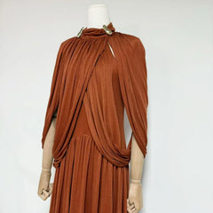 Brown draped dress on a mannequin against a white background