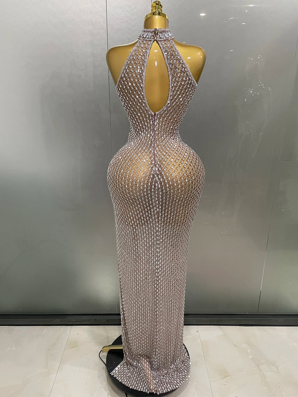 Silver beaded evening gown on a mannequin against a neutral background