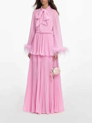 Pink pleated maxi dress with bow neck and feather trim, detail shot
