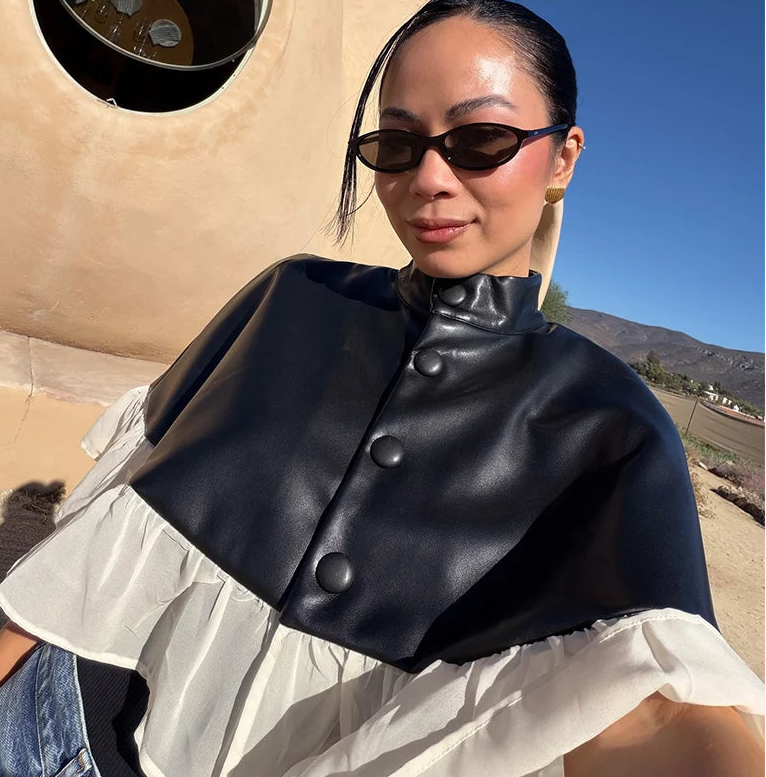 Woman wearing a black leather jacket with buttons in a desert setting