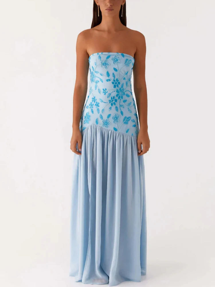 Woman wearing a strapless blue floral dress on a white background