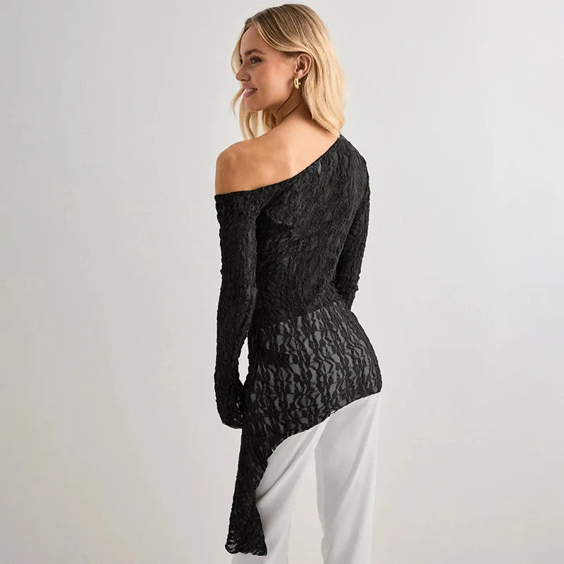 Woman wearing a black off-shoulder dress against a plain background