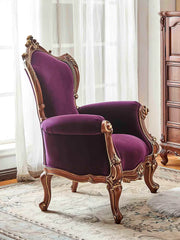Purple armchair with wooden frame in a room with curtains and a dresser.