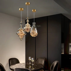 Modern brass chandelier with three glass pendant lights, illuminating a  Dinner Table. Golden Atelier  4