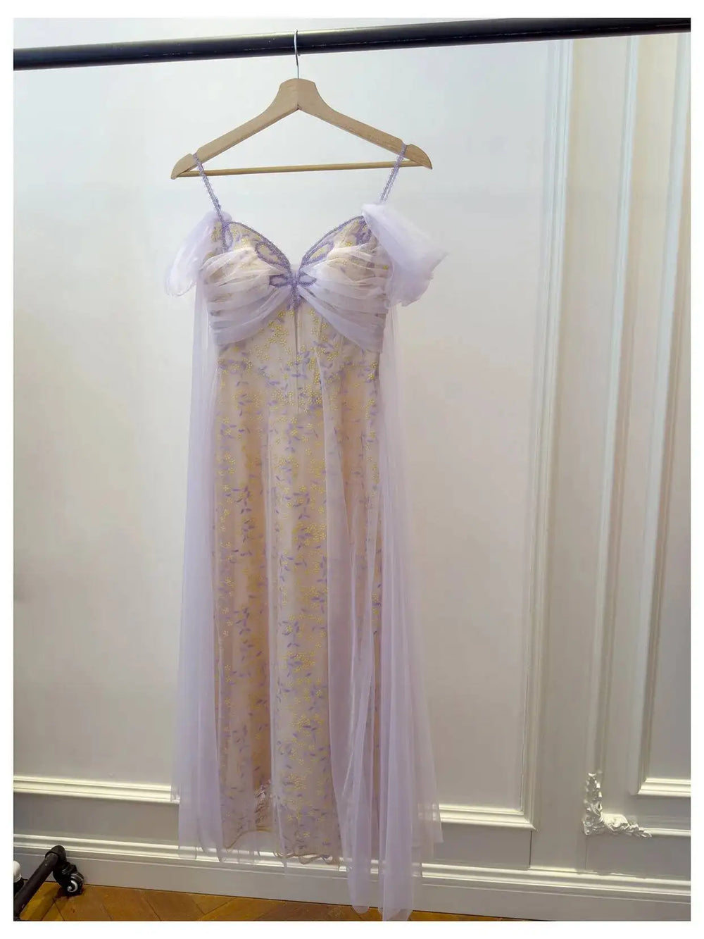 Embroidered butterfly tulle overlay maxi dress hanging on a hanger