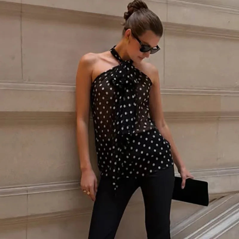 Woman wearing a black polka dot halter neck chiffon blouse