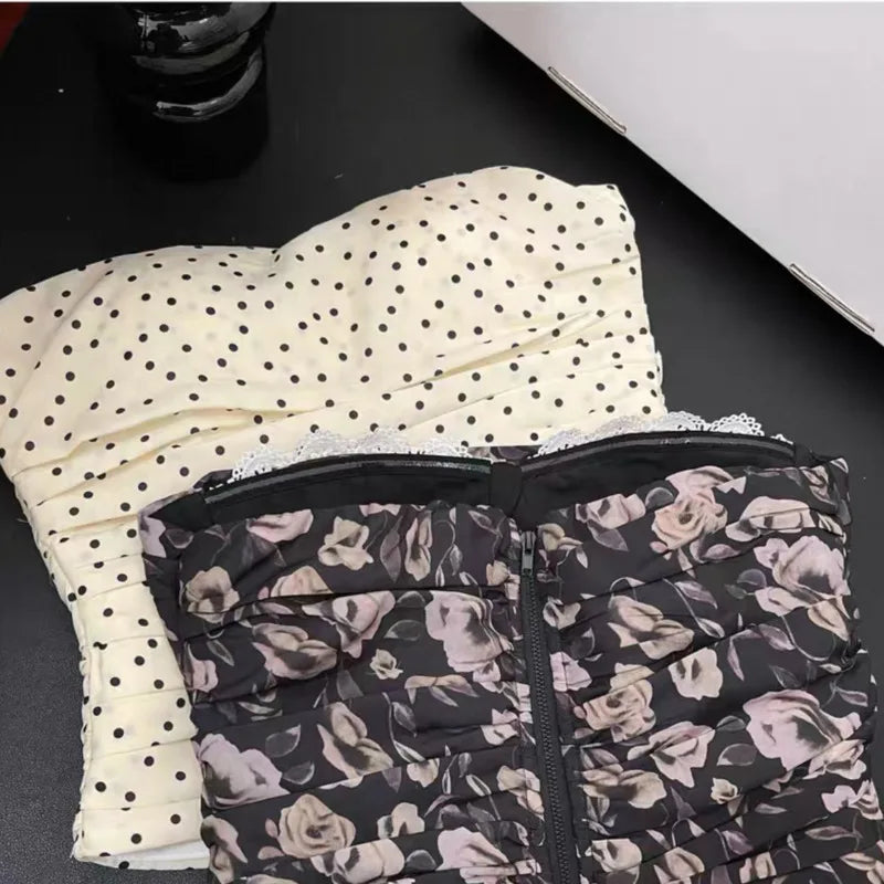 Two folded garments, one with polka dot pattern and the other with floral pattern, on a dark surface.