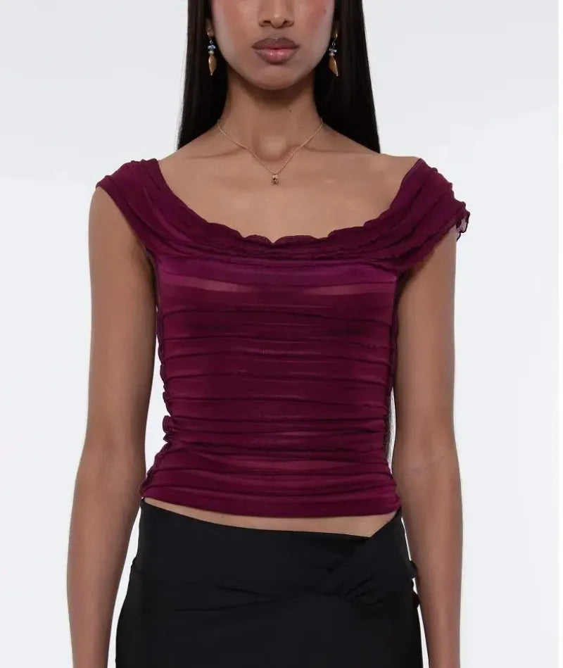 Woman wearing a burgundy top with a plain background