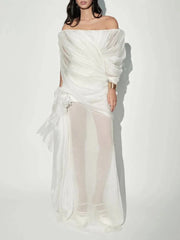 Woman wearing a white off-shoulder dress against a white background