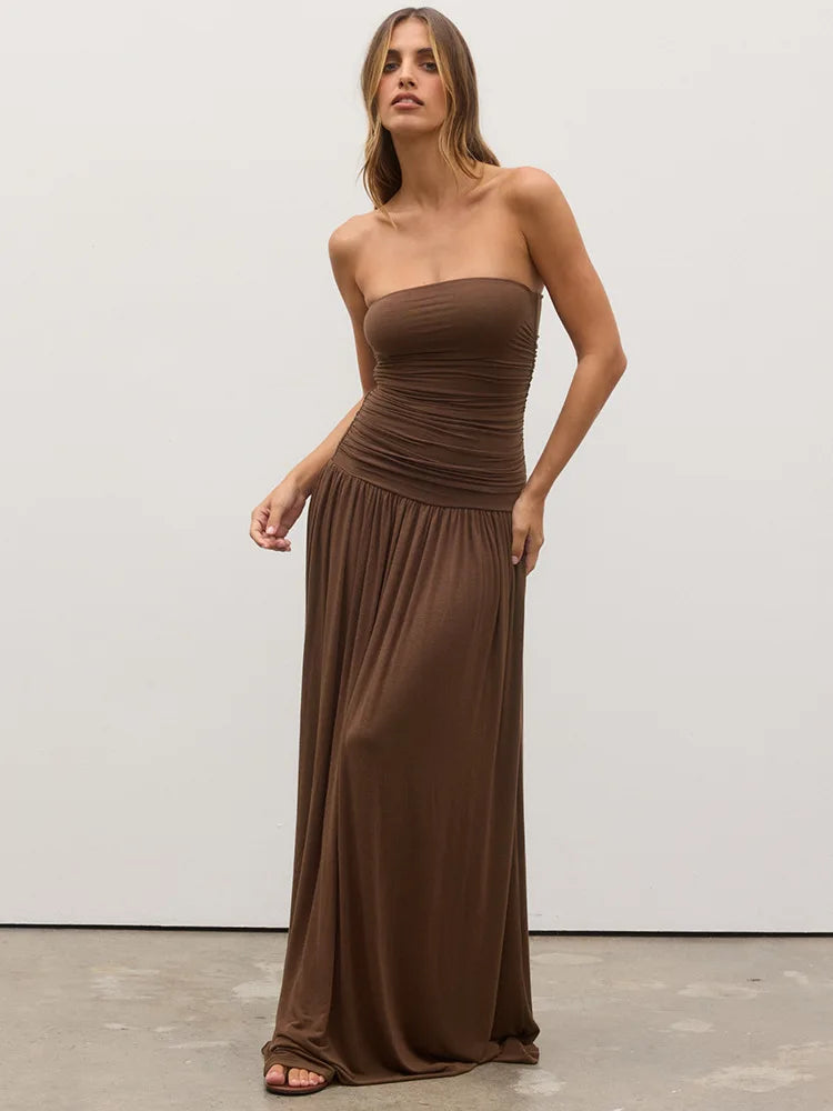 Woman wearing a brown strapless gown against a white background