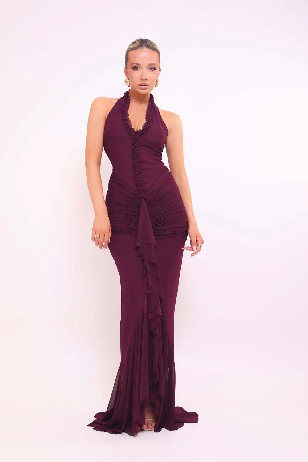 Woman wearing a burgundy evening gown against a white background