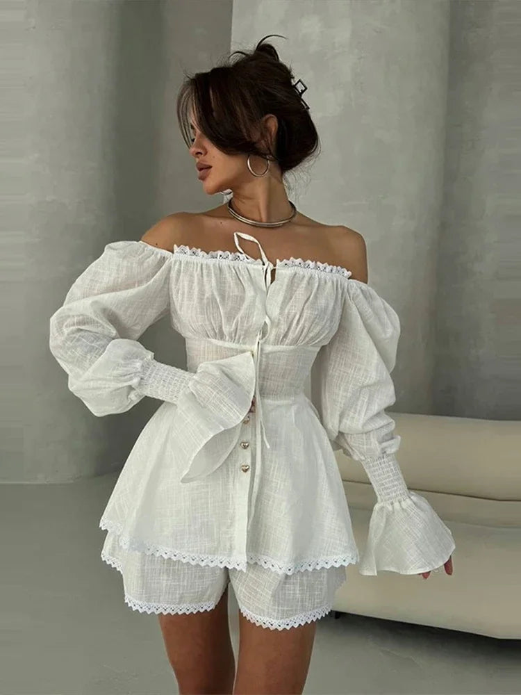 Woman wearing a white off-shoulder dress with puffed sleeves against a neutral background