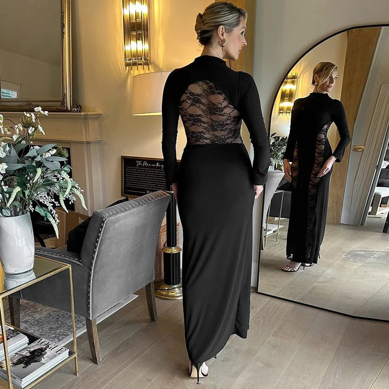 Woman in a black dress with lace detailing standing in a stylish room.