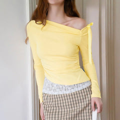 Person wearing a yellow off-shoulder top with lace detail and plaid pants 