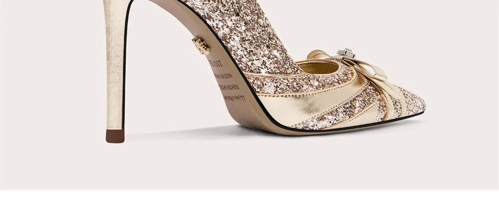 Sparkly high-heeled shoe with a bow on a white background