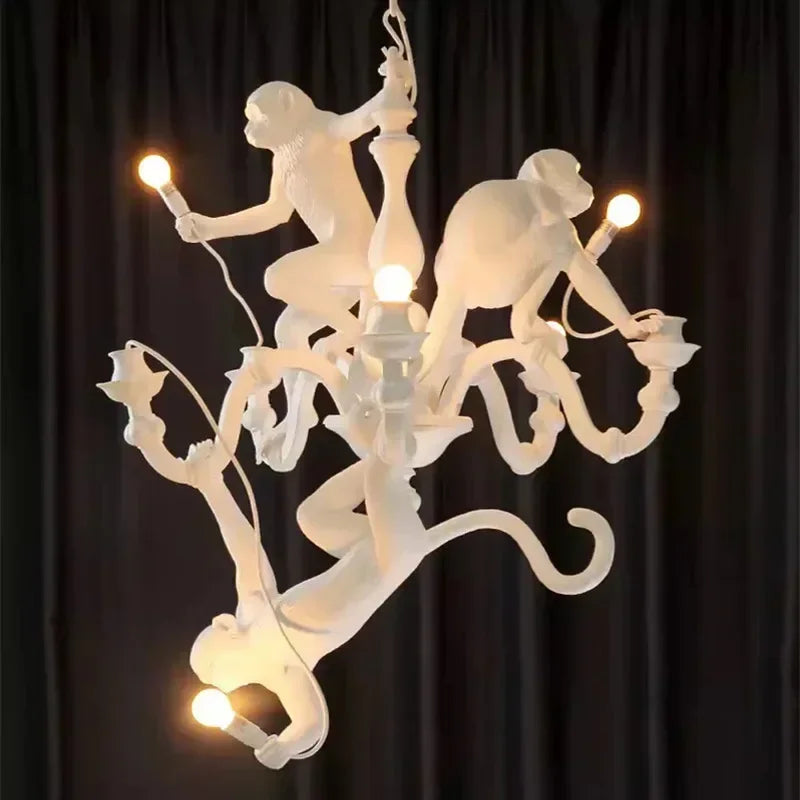 A playful retro monkey chandelier with three monkeys hanging from a branch, illuminating a modern coffee shop. A