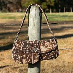 Deer print saddle bag hanging on a wooden post