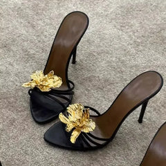 Close-up of black stiletto heels with gold floral detail