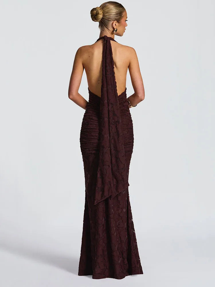Woman wearing a brown evening gown with a backless design on a white background