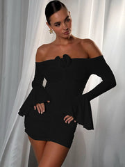 Woman wearing a black off-shoulder dress against a white curtain background