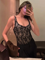 Person wearing a black lace top and holding a brown handbag.