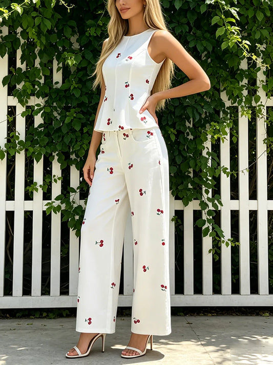 White cherry print peplum top and wide leg pants set on a woman outdoors.