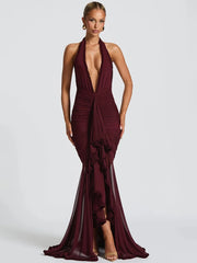 Woman wearing a burgundy halter neck gown on a white background