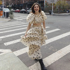 Woman in a polka dot dress crossing a street in an urban setting