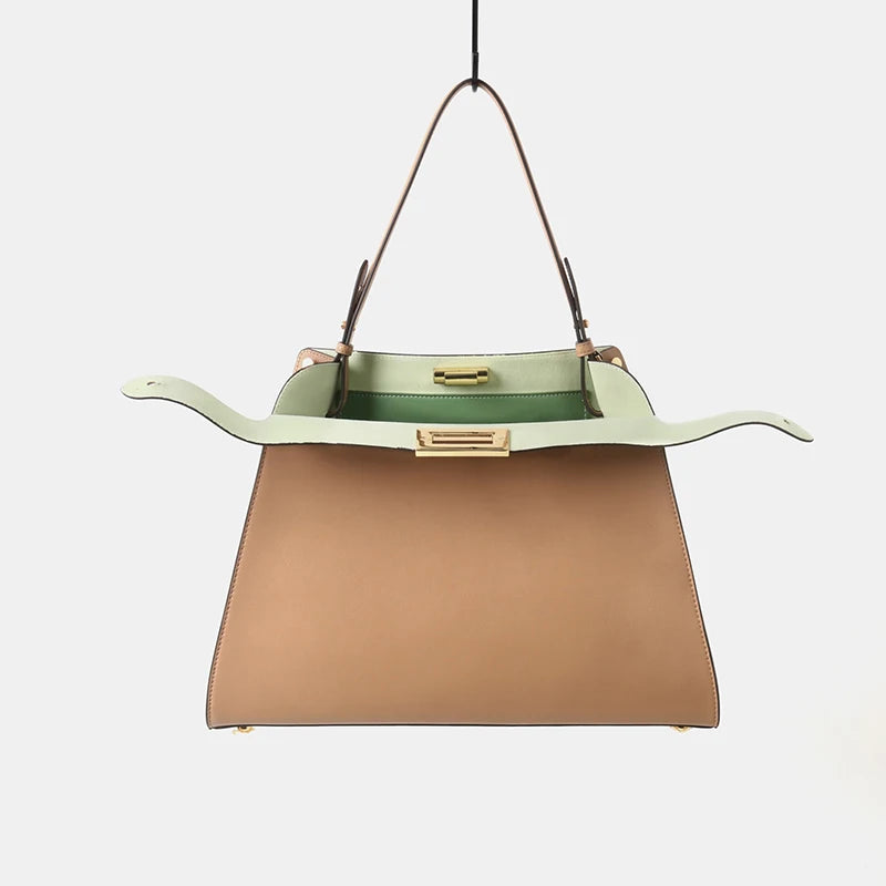Leather trapezoid top handle bag with an open top and light green interior.