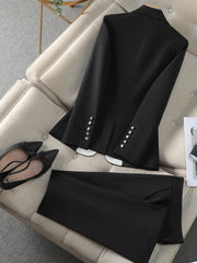 Black blazer with white buttons on a beige sofa, accompanied by black shoes.