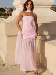Woman in a pink dress standing against a classical architecture background