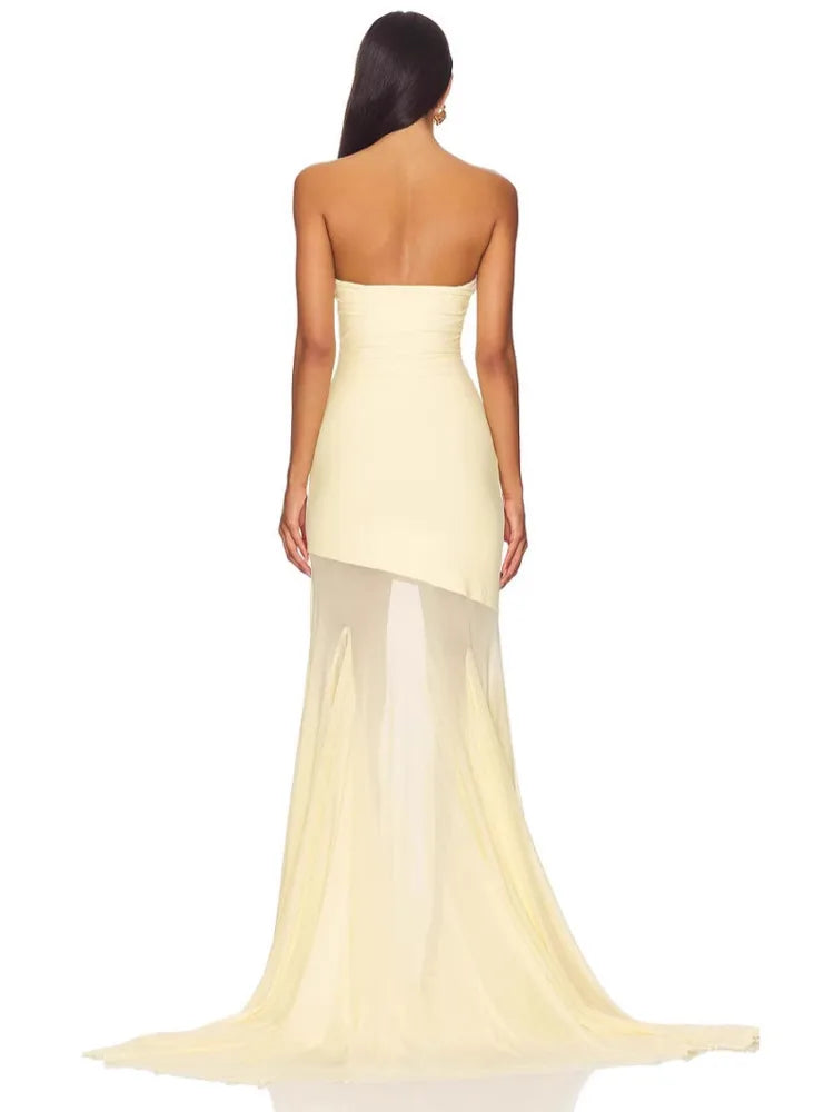 Woman wearing a strapless yellow evening gown on a white background