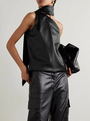 Person wearing a black sleeveless top and pants holding a matching clutch against a light gray background