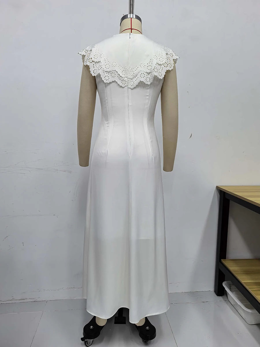 White dress with lace details on a mannequin against a plain background