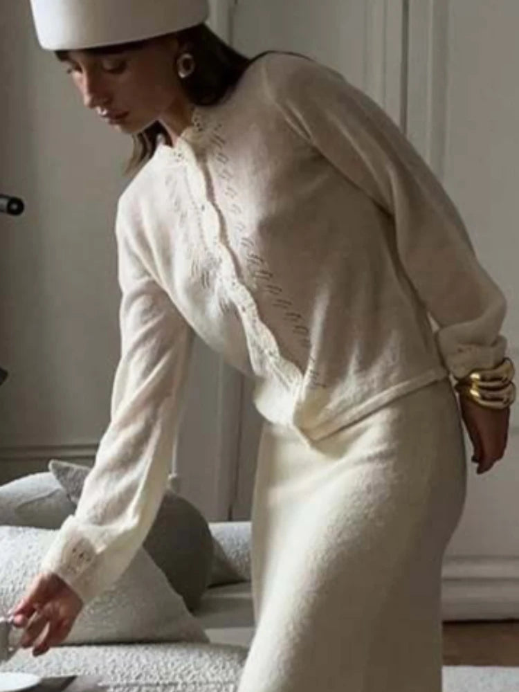 Woman in a white outfit with gold accessories in a room setting